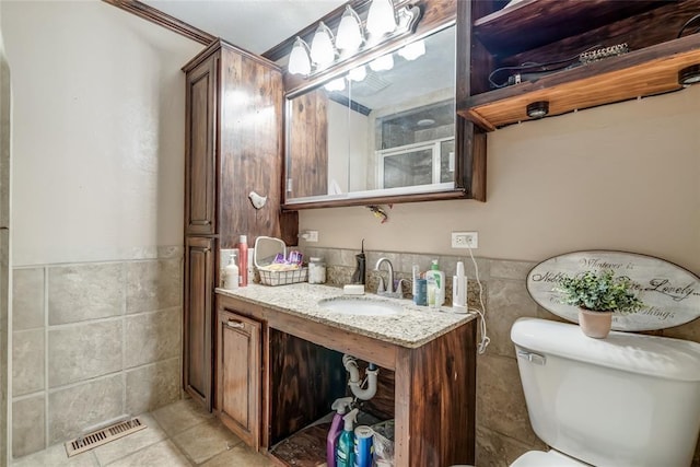 bathroom featuring tile walls, vanity, and toilet