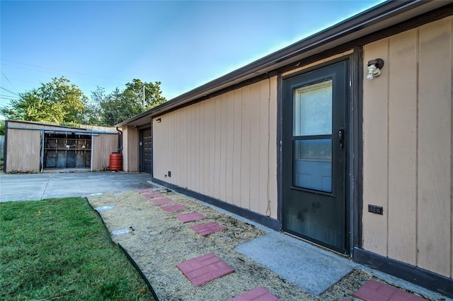 view of property exterior with an outdoor structure and a patio area