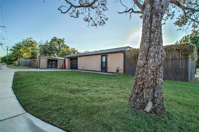 view of front of property featuring a garage, an outbuilding, and a front yard