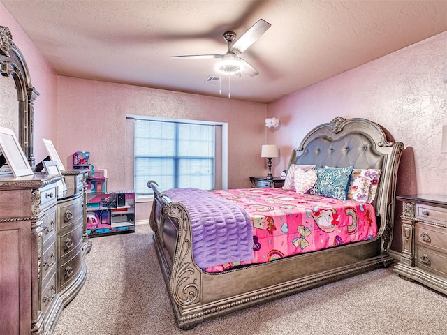 carpeted bedroom featuring ceiling fan and a textured ceiling