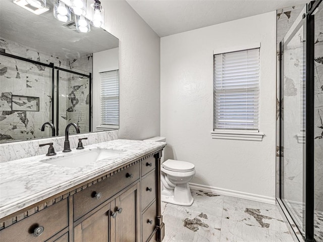 bathroom with vanity, toilet, and a shower with door