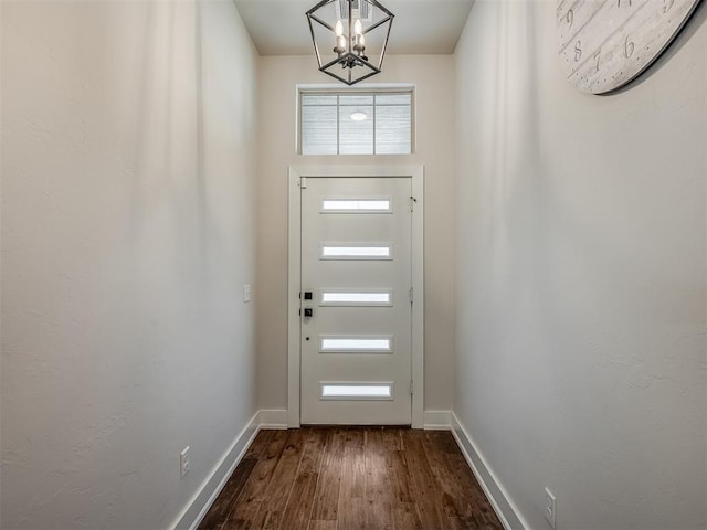 doorway to outside with plenty of natural light, a chandelier, and wood-type flooring