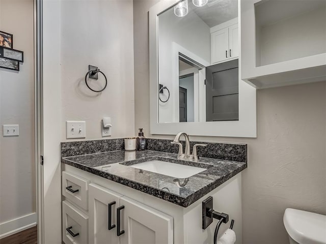 bathroom with vanity, wood-type flooring, and toilet