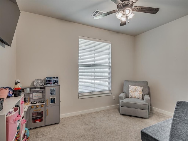 sitting room with ceiling fan and light colored carpet