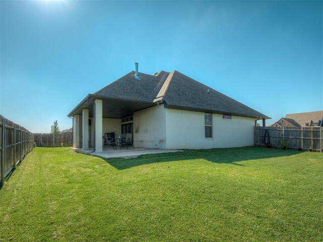 rear view of house featuring a yard and a patio area