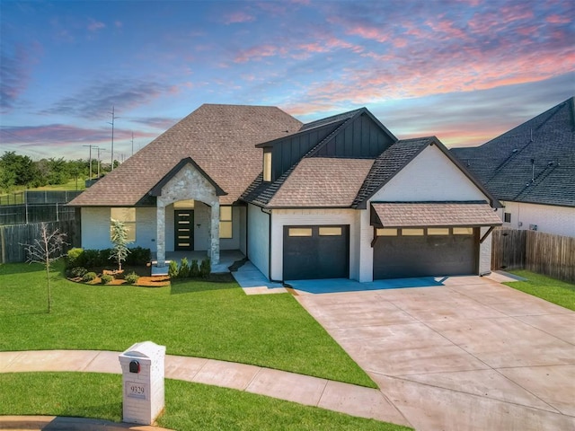 view of front of property with driveway, fence, a yard, board and batten siding, and a garage