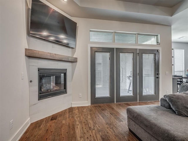 entryway featuring a tiled fireplace, wood finished floors, and baseboards