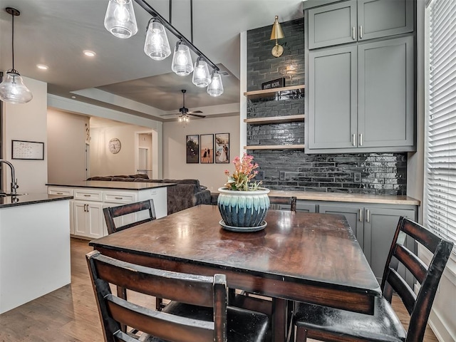 dining space featuring a tray ceiling, recessed lighting, dark wood-style floors, and ceiling fan