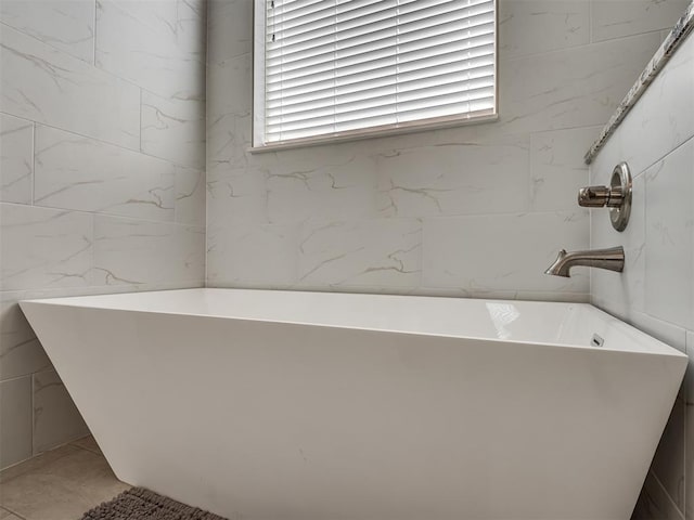 full bathroom featuring a soaking tub and tile walls