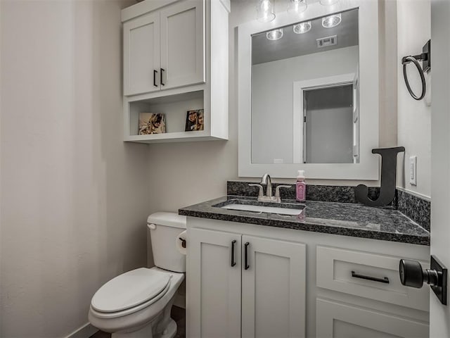 half bathroom with visible vents, toilet, and vanity