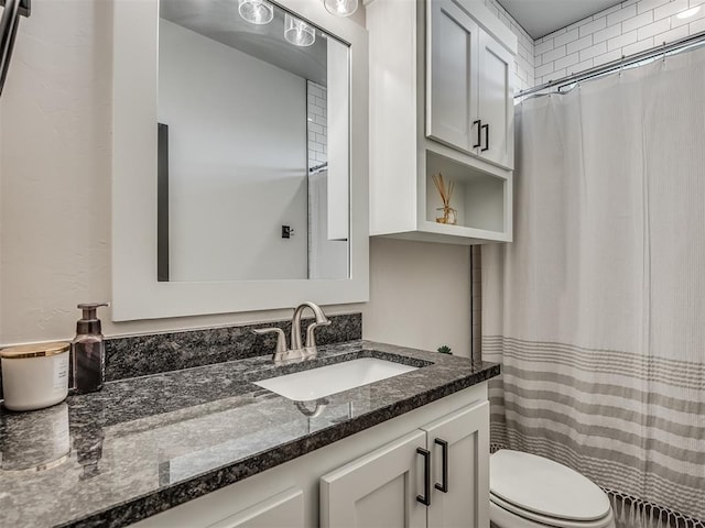 bathroom with curtained shower, toilet, and vanity