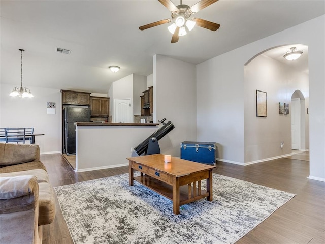 living room featuring dark hardwood / wood-style floors and ceiling fan with notable chandelier