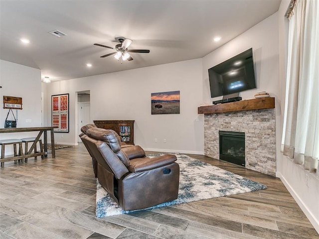 living room with a fireplace and ceiling fan