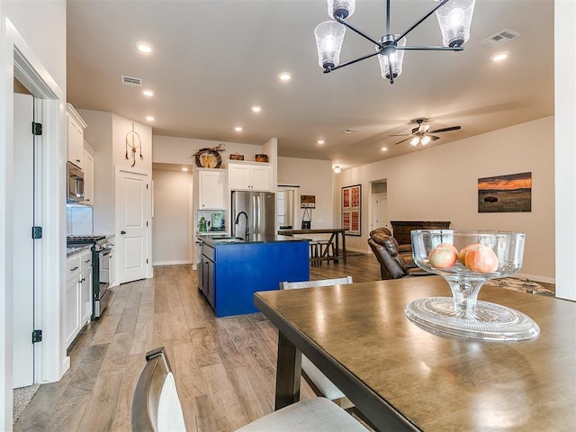 dining space featuring ceiling fan, sink, and light hardwood / wood-style flooring