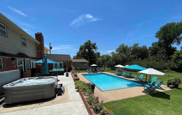 view of pool with a yard, a hot tub, and a patio