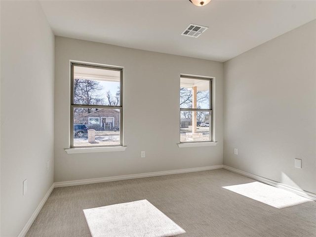 empty room with light colored carpet and plenty of natural light