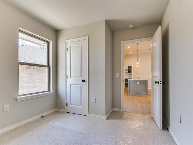 unfurnished bedroom featuring light colored carpet and multiple windows