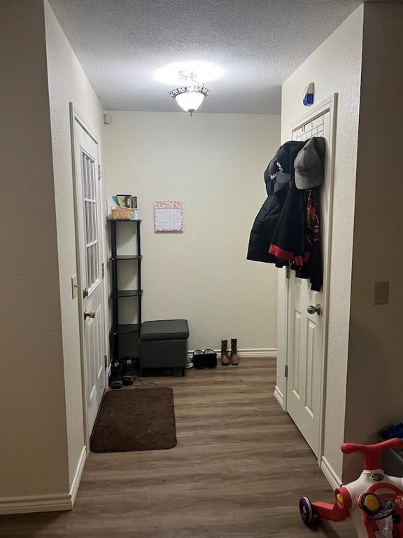 hallway with dark wood-type flooring and a textured ceiling