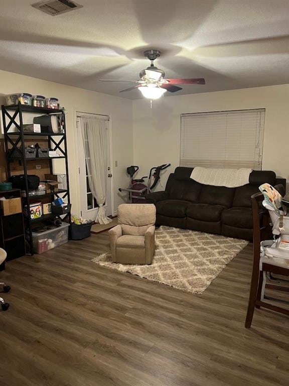 living room with dark wood-type flooring and ceiling fan