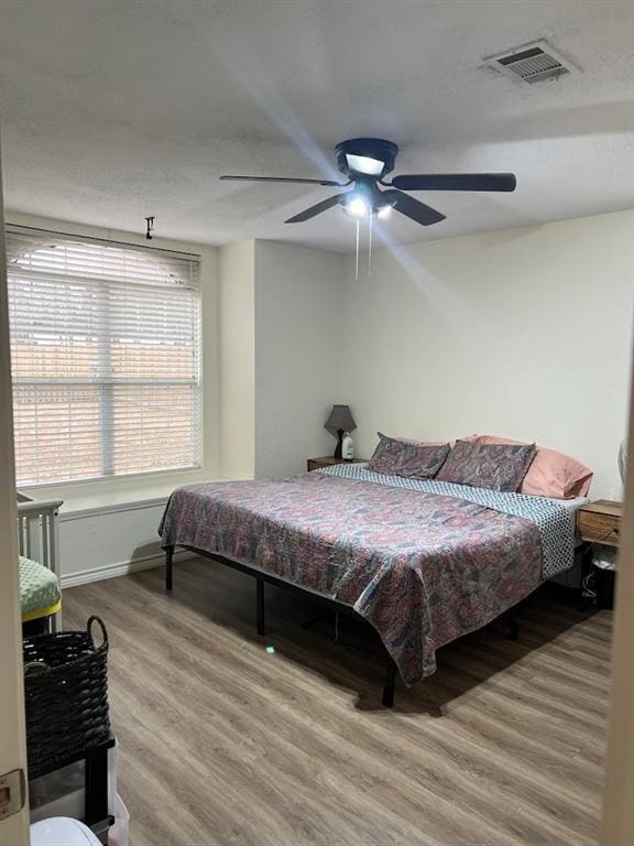 bedroom with hardwood / wood-style floors and ceiling fan