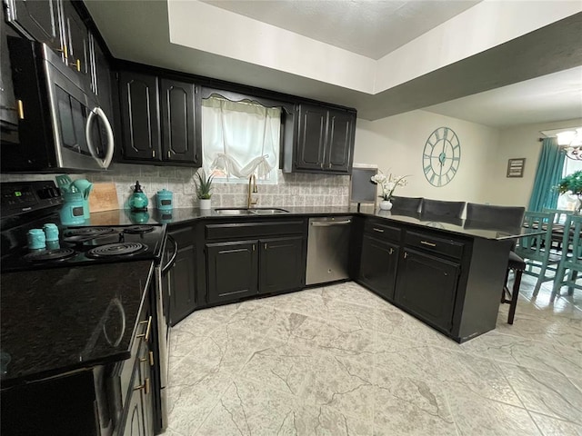 kitchen featuring stainless steel appliances, a raised ceiling, sink, and decorative backsplash