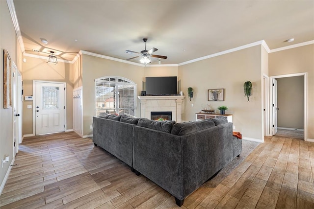 living room featuring crown molding, ceiling fan, and light hardwood / wood-style flooring