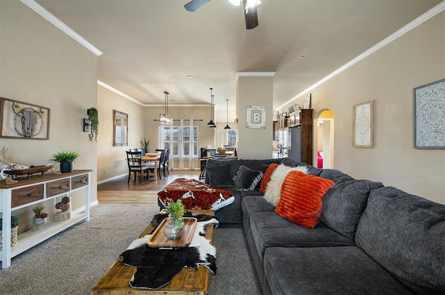 living room featuring ornamental molding, wood-type flooring, and ceiling fan