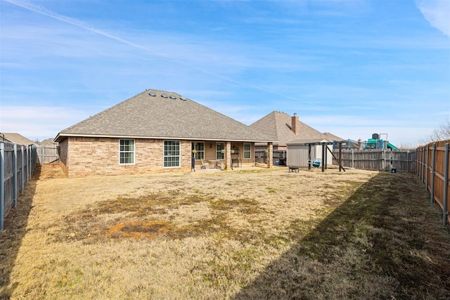 rear view of house with a playground, a yard, and a shed