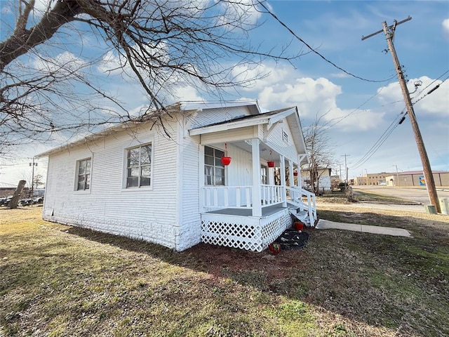 view of property exterior featuring a yard and a porch