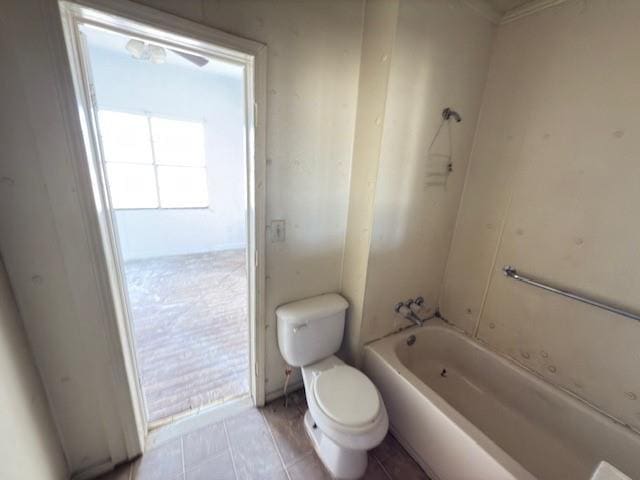 bathroom with  shower combination, plenty of natural light, and toilet