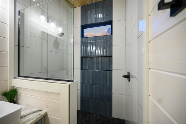 bathroom with tiled shower and sink