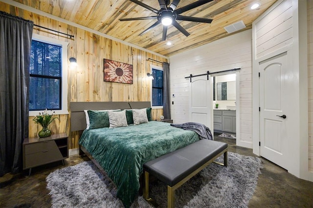 bedroom featuring a barn door, wooden walls, wood ceiling, and ensuite bath