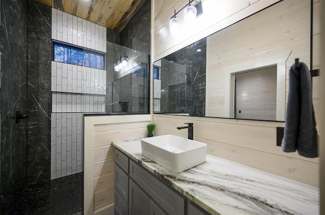 bathroom featuring tiled shower and vanity