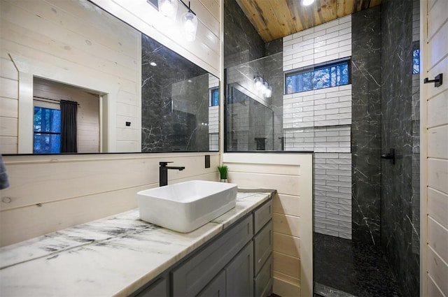 bathroom featuring wooden ceiling, vanity, and a tile shower