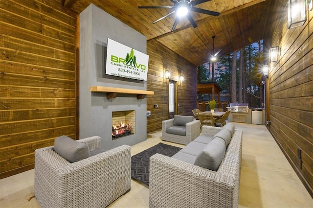 home theater with an outdoor fireplace, ceiling fan, wood ceiling, and wooden walls