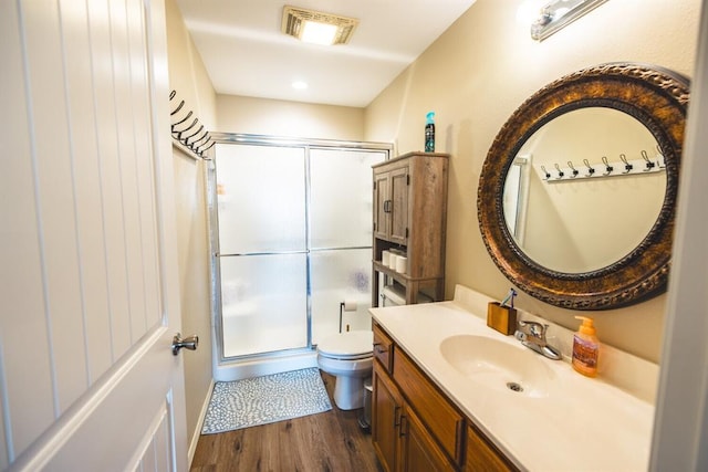 bathroom featuring walk in shower, vanity, toilet, and hardwood / wood-style flooring