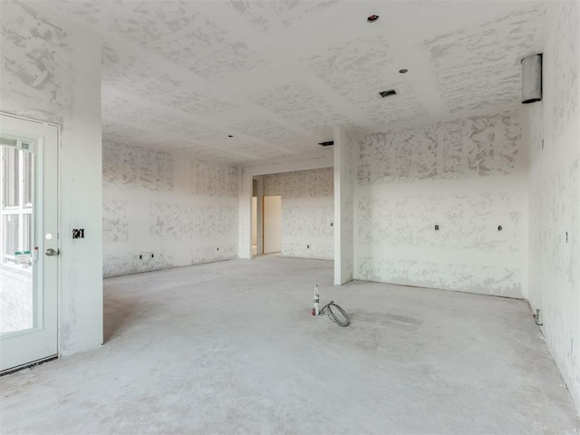 empty room with a healthy amount of sunlight and unfinished concrete floors