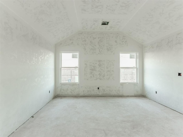 spare room with lofted ceiling, plenty of natural light, and visible vents