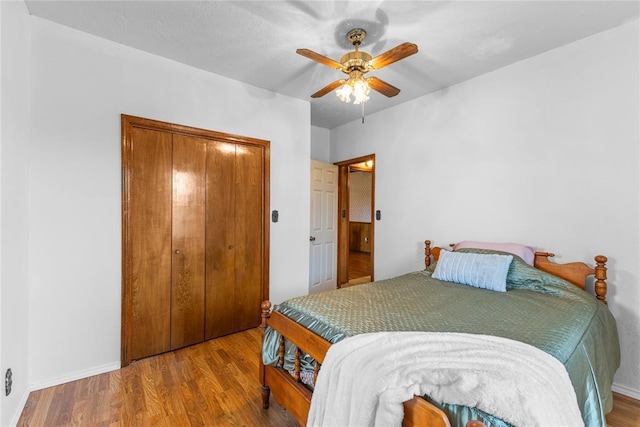 bedroom featuring baseboards, a closet, a ceiling fan, and wood finished floors