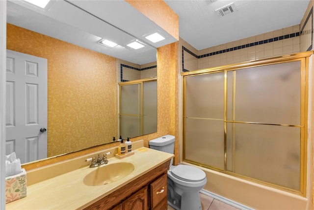 full bathroom with vanity, visible vents, toilet, combined bath / shower with glass door, and tile patterned floors