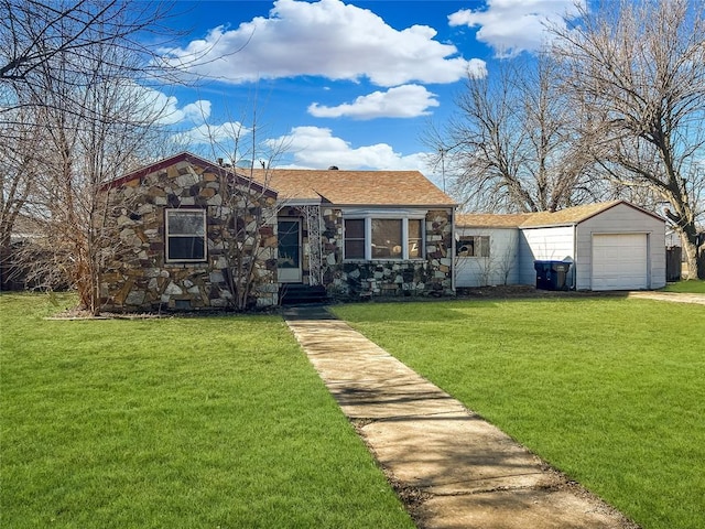 view of front of property featuring an outbuilding, a detached garage, stone siding, driveway, and a front yard