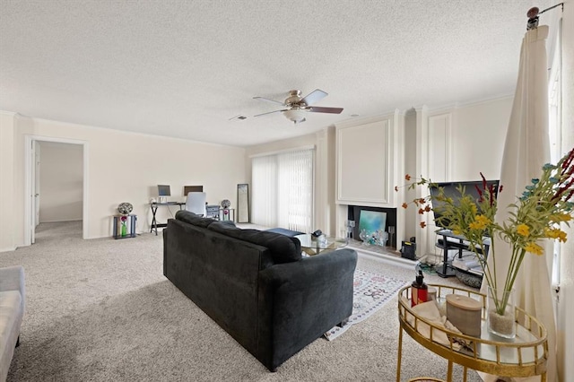 living room with ceiling fan, carpet flooring, and a textured ceiling