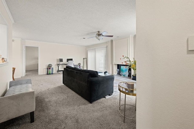 carpeted living room with crown molding, ceiling fan, and a textured ceiling