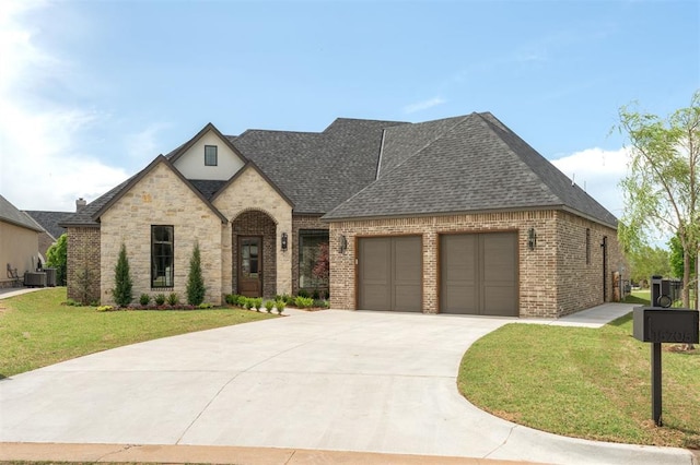 french provincial home with driveway, brick siding, an attached garage, a shingled roof, and a front yard