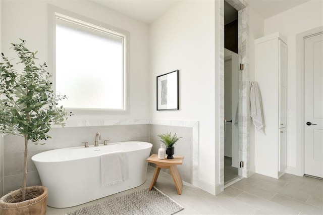bathroom featuring tile patterned flooring, a shower stall, and a freestanding bath
