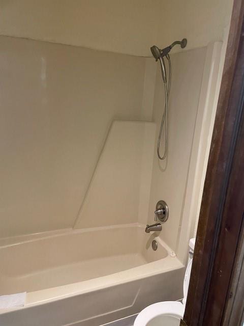 bathroom with shower / washtub combination and toilet