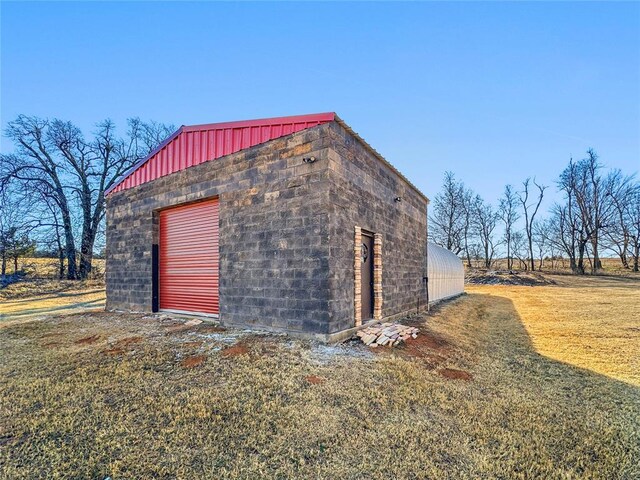 view of outbuilding featuring a garage and a lawn