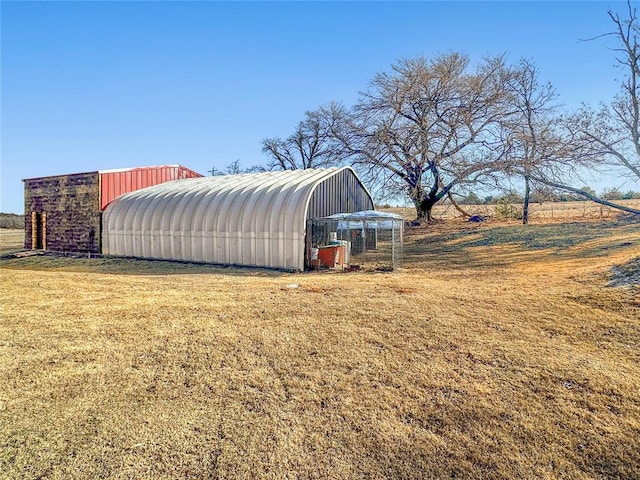 view of outbuilding featuring a rural view and a yard