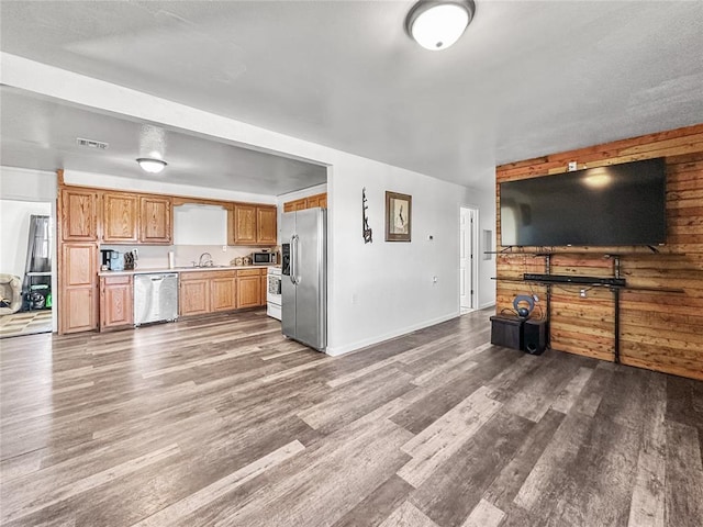 unfurnished living room featuring wood-type flooring and sink