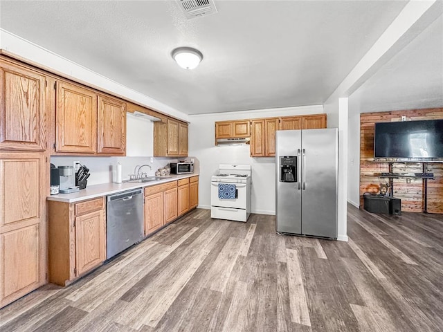 kitchen featuring appliances with stainless steel finishes, sink, and light wood-type flooring